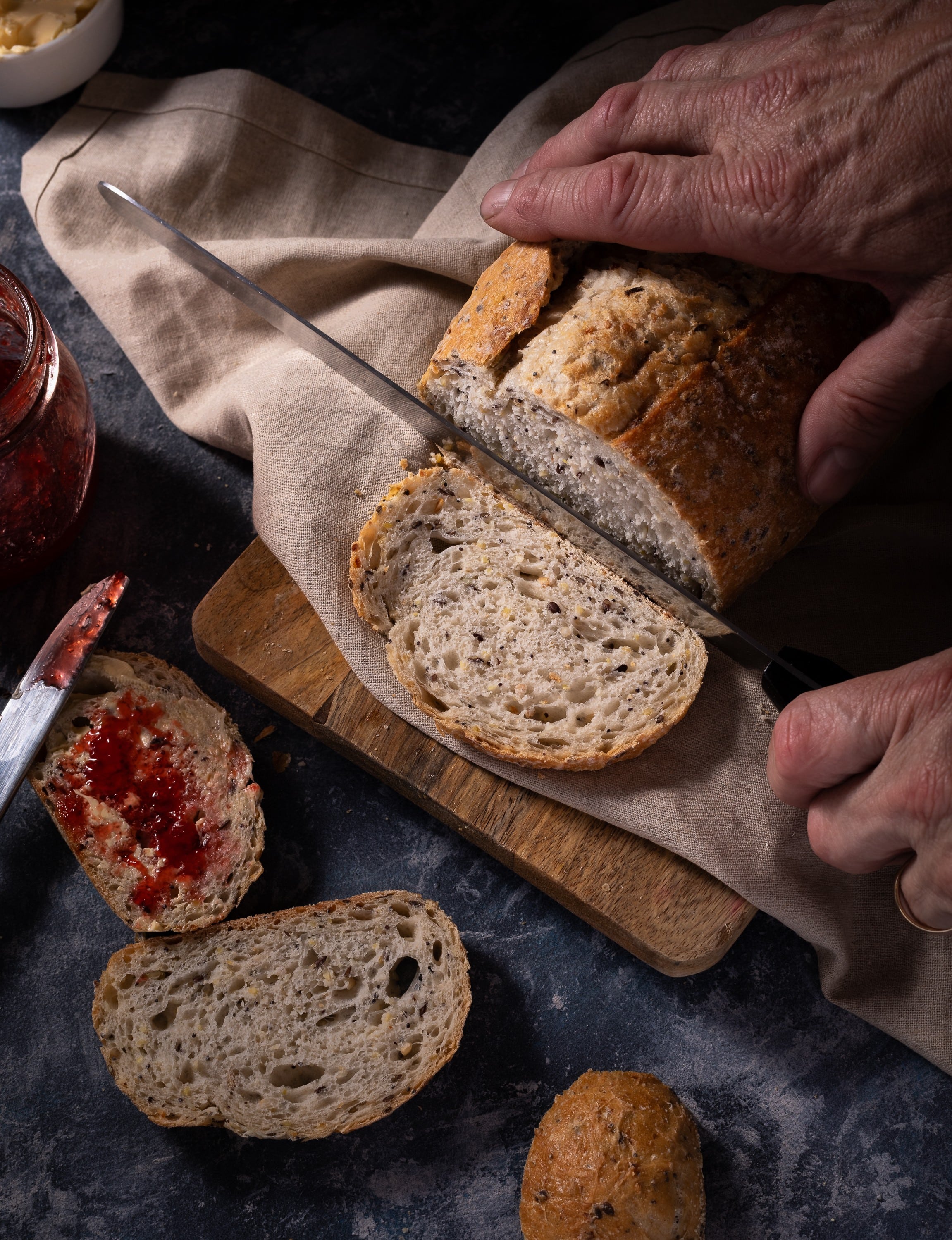 A photo of Vienna multigrain bread being sliced in a country style setting. Copyright Steve Wickenton