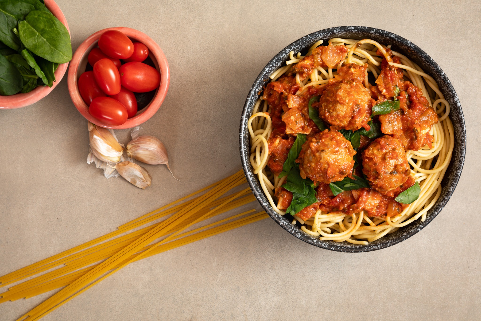 Spaghetti and meatballs styled with fresh produce and pasta for food photography by Steve Wickenton